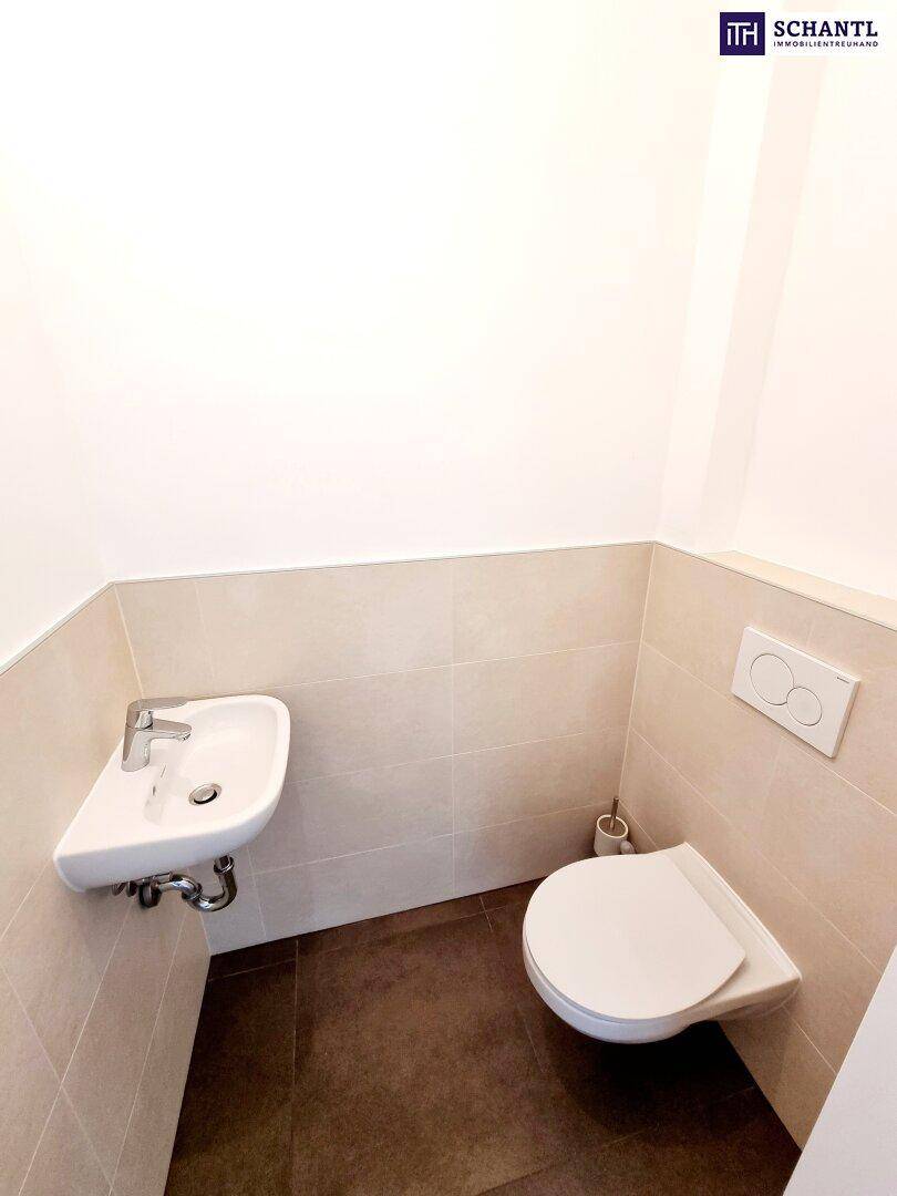 Modernes Gäste-WC mit wandhängendem WC und kleinem Waschbecken.