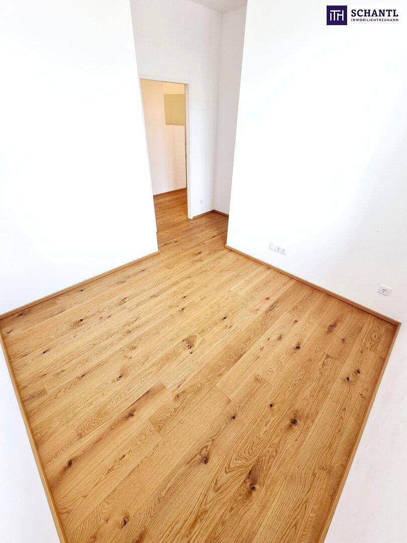 Helles Zimmer mit Eichenparkett und weißen Wänden, ideal als Schlaf- oder Arbeitszimmer.