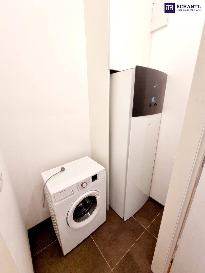 Kleiner Hauswirtschaftsraum mit Waschmaschine und moderner Wärmepumpe.