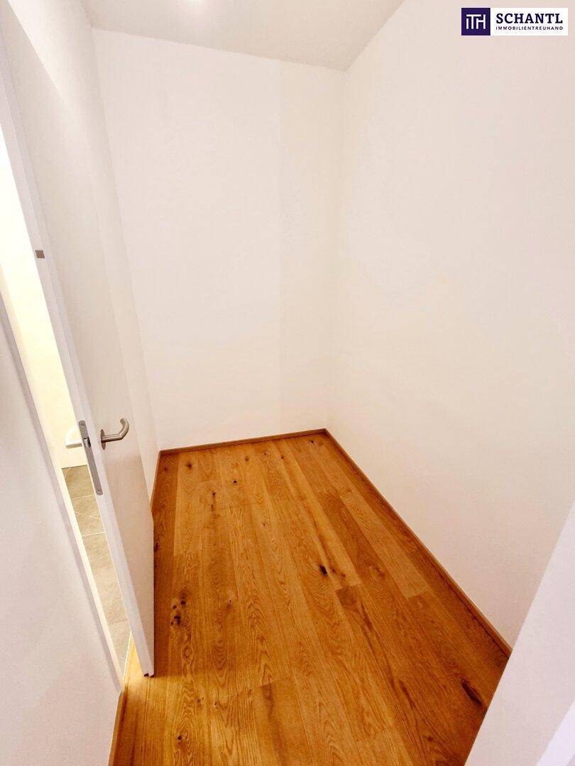 Kleiner Abstellraum mit Holzboden und weißen Wänden.