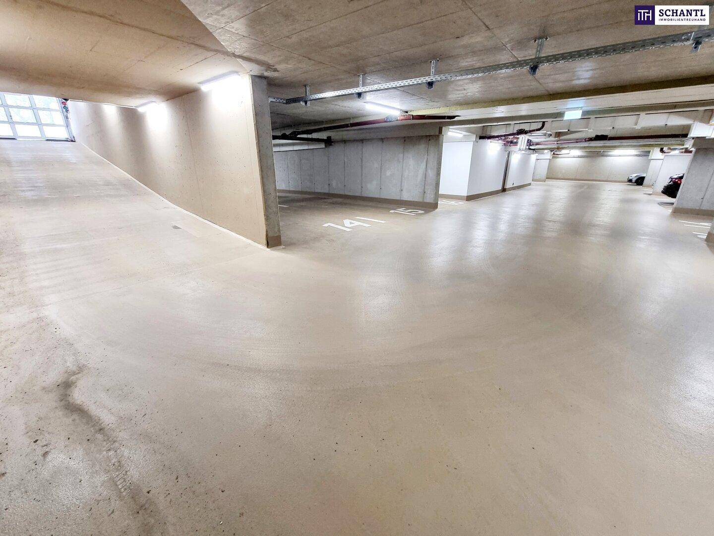 Geräumige Tiefgarage mit Betonboden und ausreichend Stellplätzen für Fahrzeuge in einem Neubau.