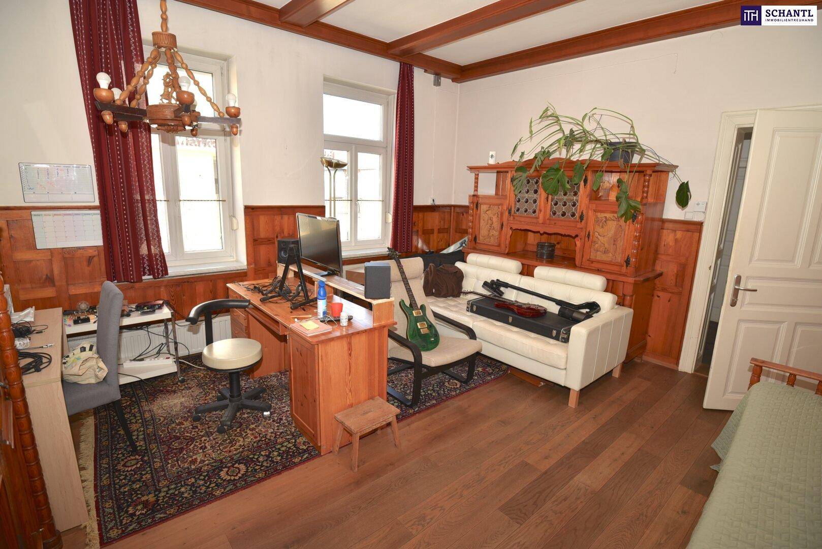 Geräumiges Arbeitszimmer mit Holzboden, Holzvertäfelung und traditionellen Möbeln.