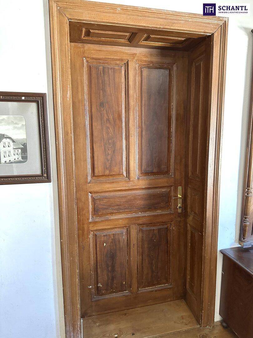 Detailansicht einer traditionellen Holztür mit Rahmen und klassischem Design.