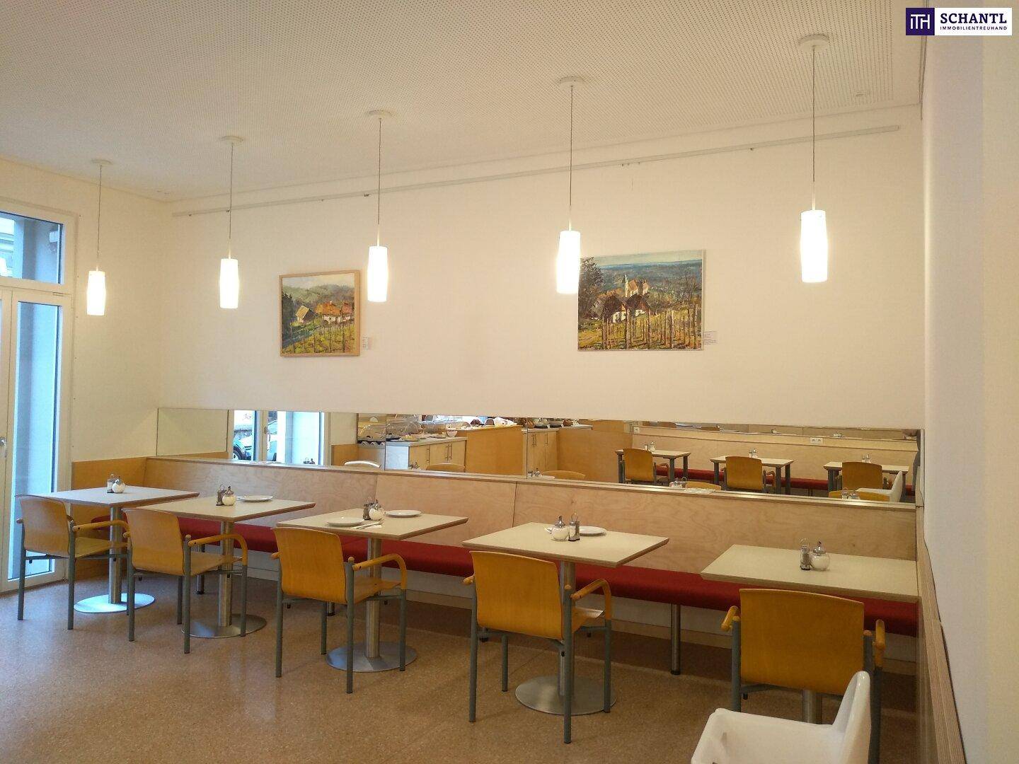 Heller Speisesaal mit mehreren Tischen, Bänken und Stühlen, ideal für Frühstück.