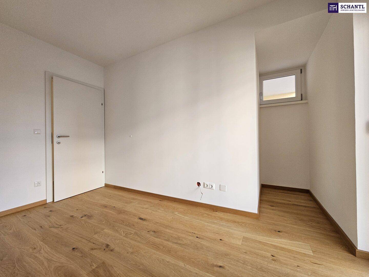 Helles Zimmer mit Parkettboden und einem kleinen Fenster, ideal als Kinder- oder Arbeitszimmer.