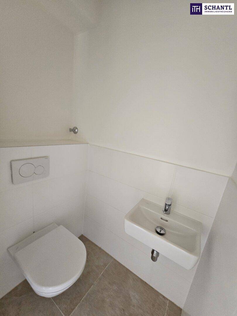 Modernes Gäste-WC mit wandhängender Toilette und kleinem Waschbecken.