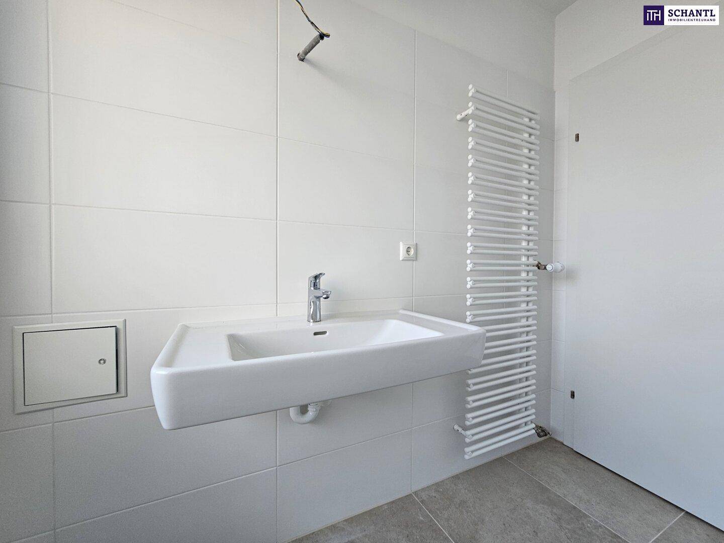 Modernes Badezimmer mit Waschbecken, Fliesen und beheiztem Handtuchhalter.