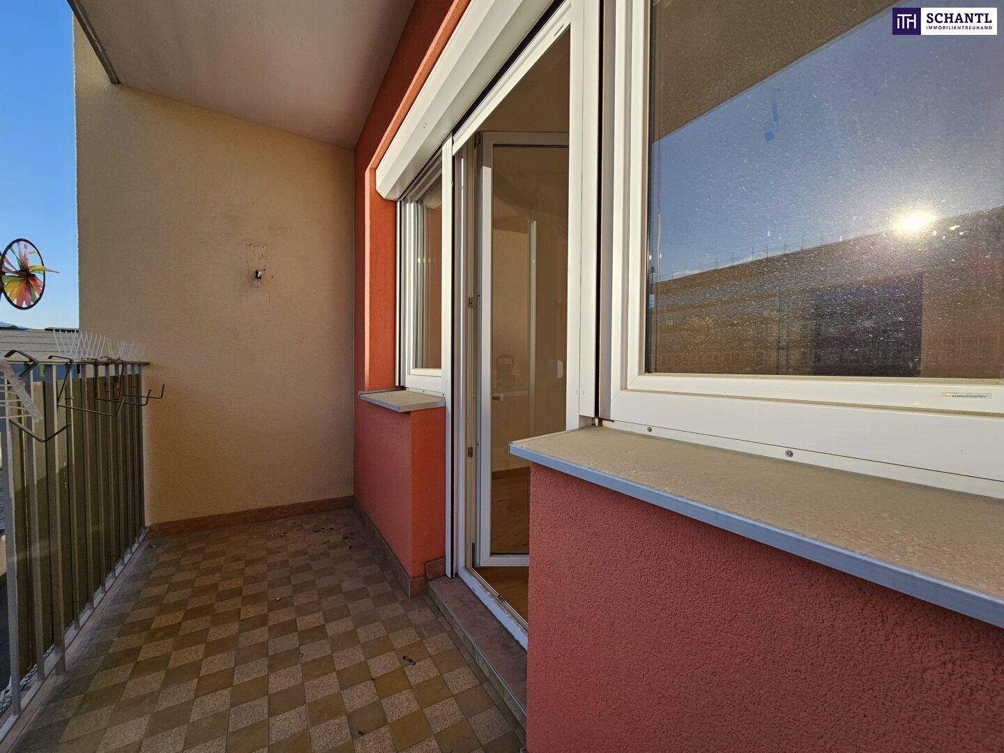 Sonniger Balkon mit Fliesenboden und Blick auf die umliegenden Gebäude.