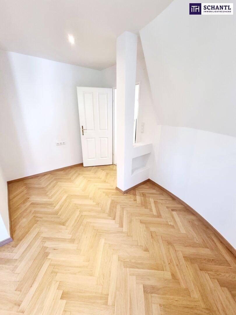 Kleinerer Dachgeschossraum mit Parkettboden und weiß gestrichenen Wänden.