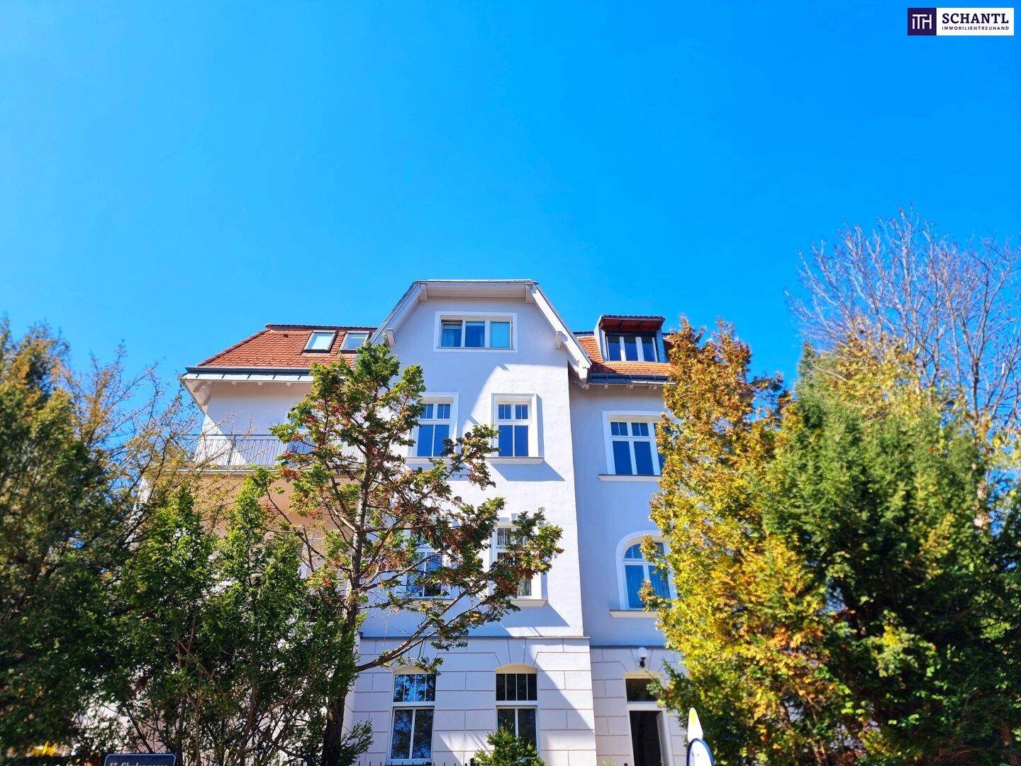 Historisches Gebäude mit klassischer Architektur, roten Dachziegeln und vielen Fenstern.