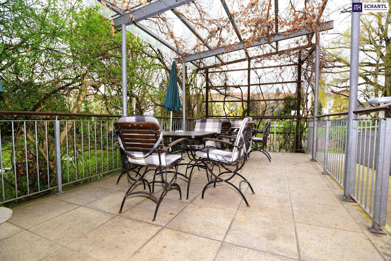 Geräumige Terrasse mit Pergola, Gartenmöbeln und Blick ins Grüne.