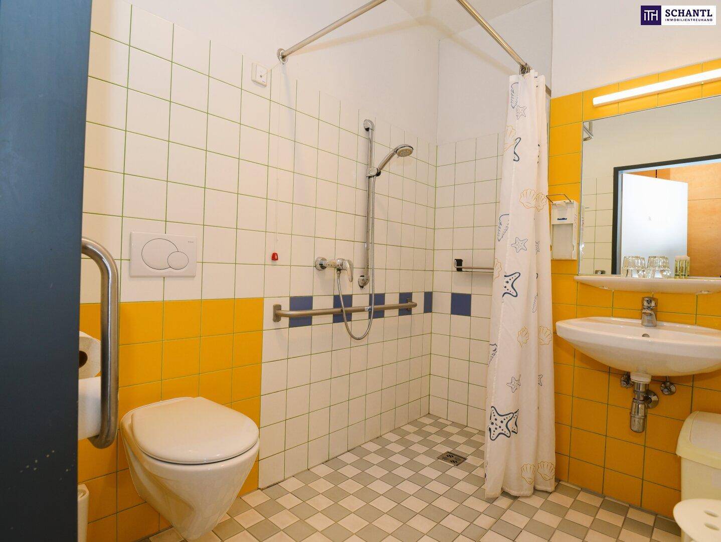 Barrierefreies Badezimmer mit ebenerdiger Dusche, Toilette und Haltegriffen für Komfort.