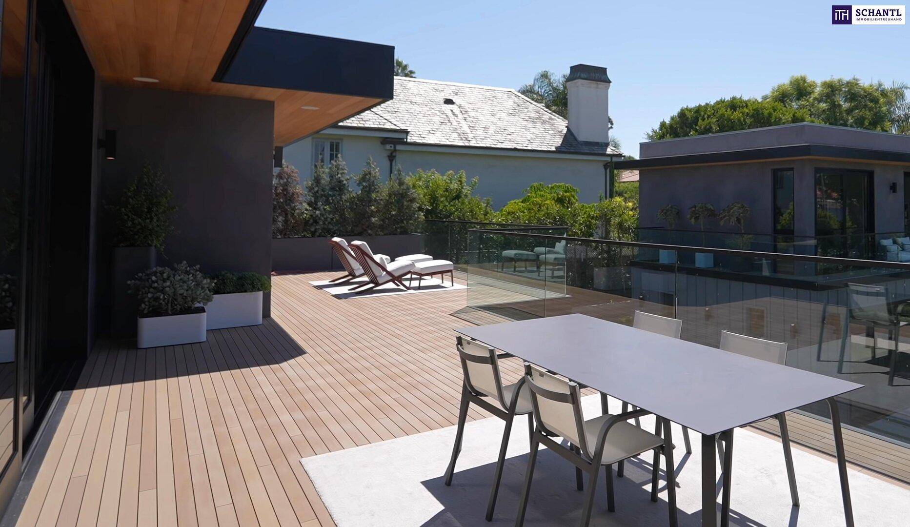Großzügige Holzterrasse mit Essbereich und Sonnenliegen, umgeben von Glasgeländern.