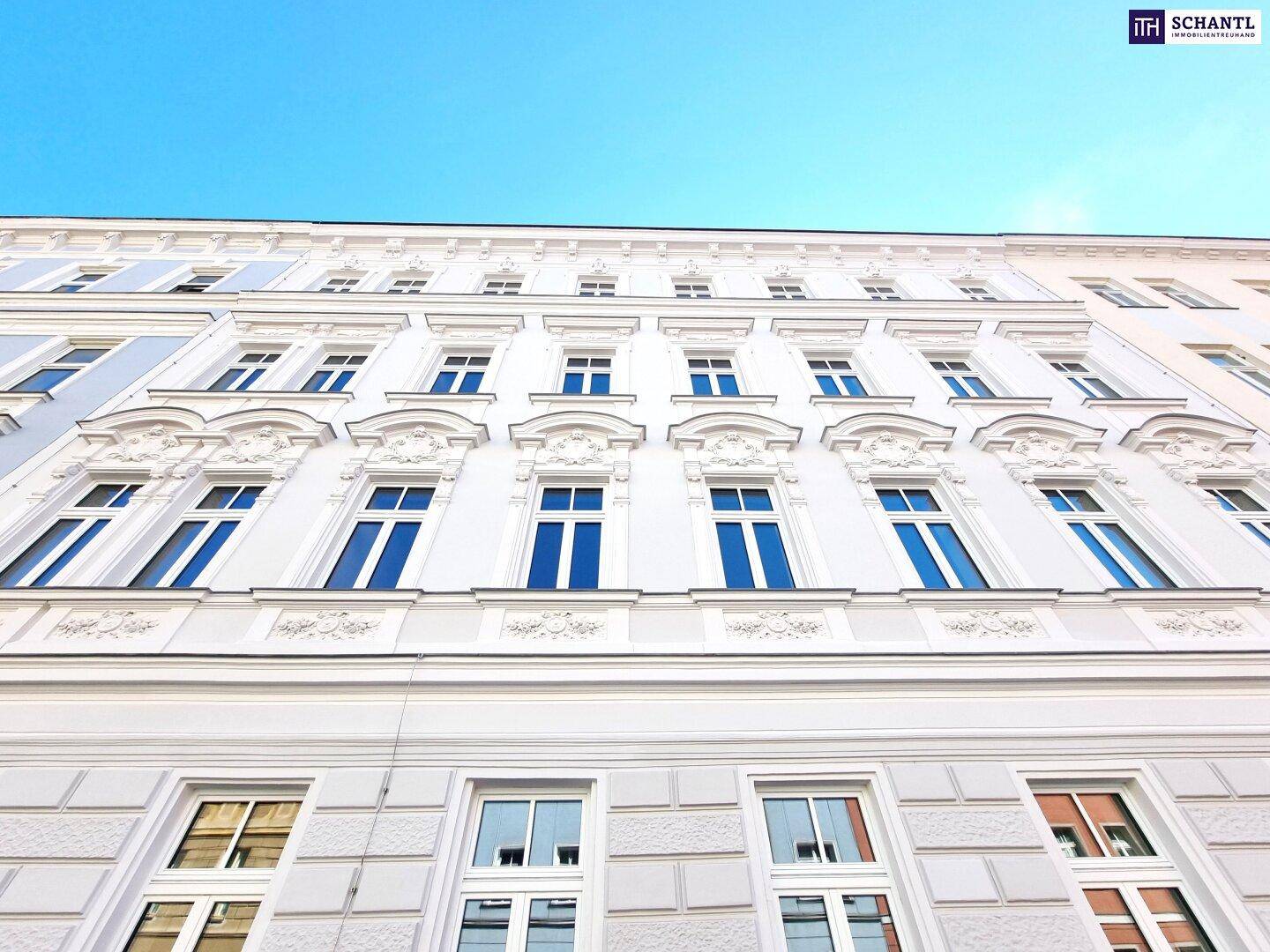 Eindrucksvolle historische Fassade eines Altbaus mit reich verzierten Fenstern und Stuckelementen.