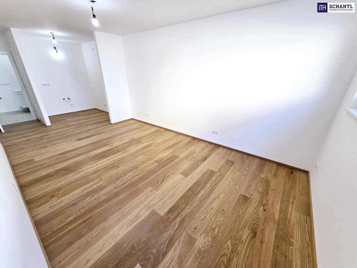 Geräumiger, heller Raum mit glänzendem Holzparkettboden und weißen Wänden, bereit zur Einrichtung.