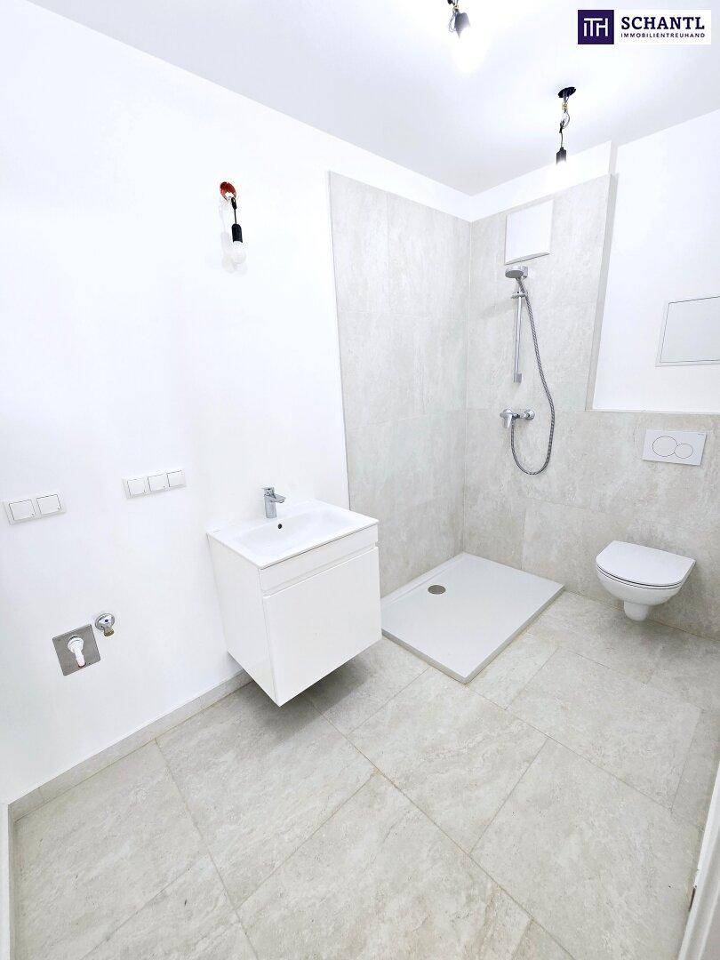 Modernes Badezimmer mit Duschbereich, wandhängendem WC und Waschbeckenunterschrank.