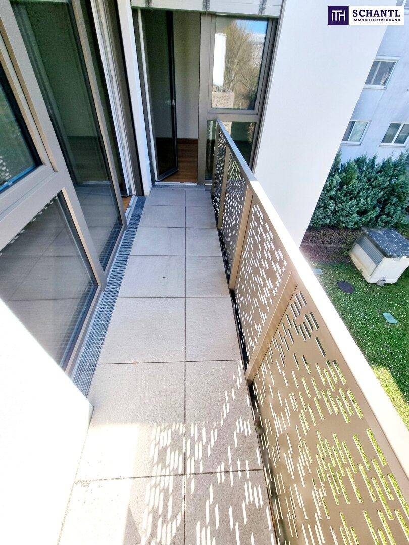 Moderner Balkon mit Fliesenboden und dekorativem Geländer, bietet Blick ins Grüne.