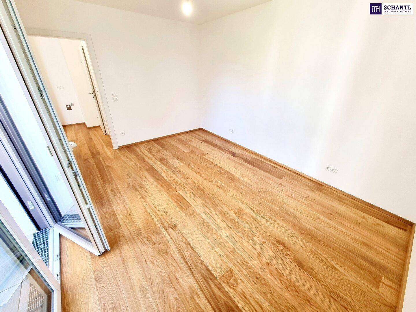 Ruhiges, helles Zimmer mit Eichenparkett und weiß gestrichenen Wänden, ideal als Schlafzimmer.