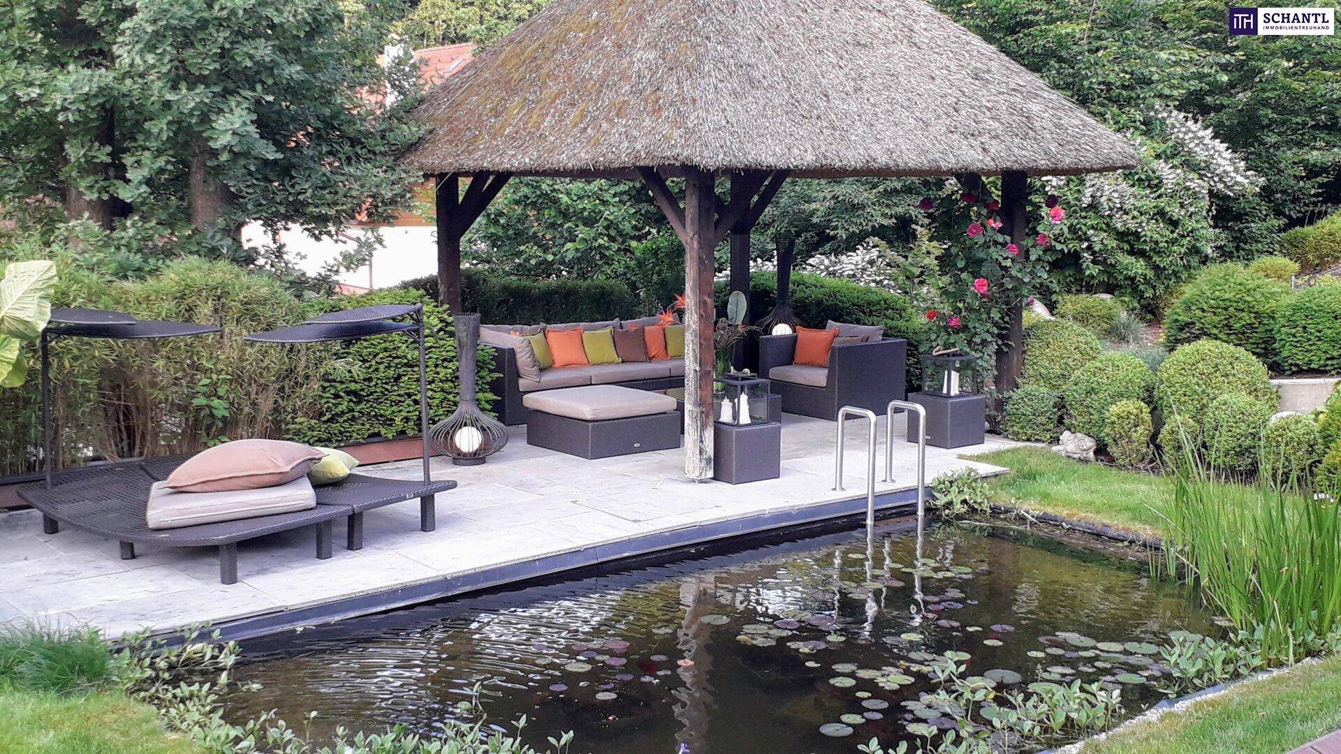 Idyllischer Gartenbereich mit Teich, Liegeflächen und einem charmanten Strohdach-Pavillon.