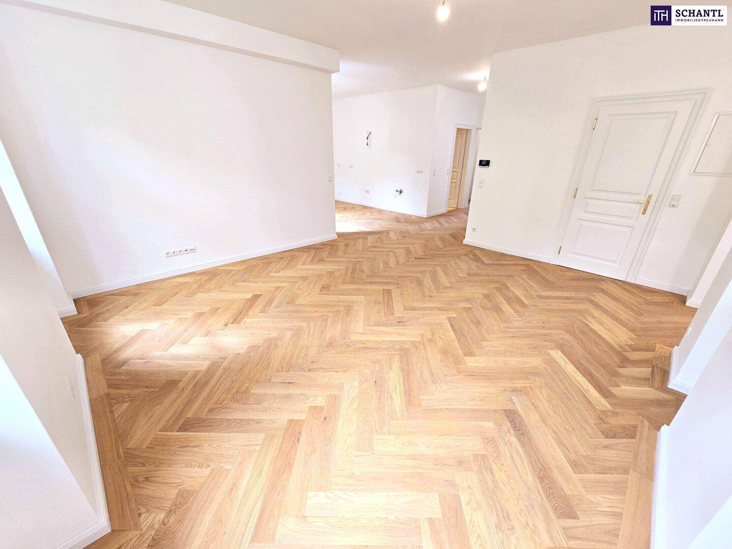Geräumiges, helles Zimmer mit elegantem Fischgrätparkett und weißen Wänden, ideal für Wohnzwecke.