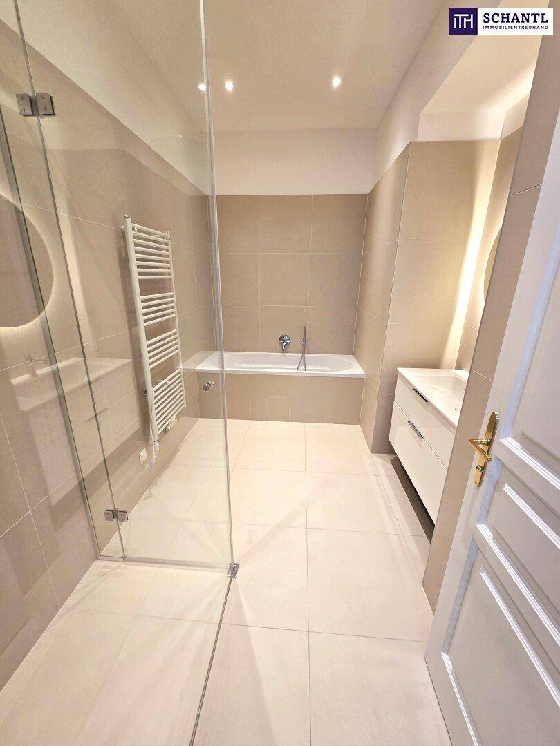 Modernes Badezimmer mit Badewanne, begehbarer Dusche und beheiztem Handtuchhalter.