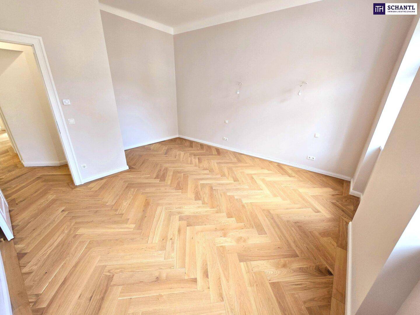 Geräumiges, helles Zimmer mit Fischgrätparkett und hohen Decken, bereit zur Einrichtung.