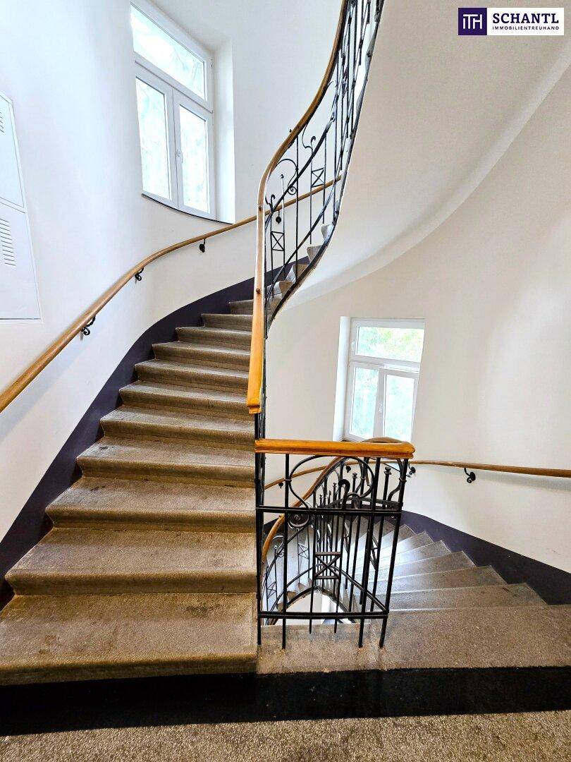 Elegantes Treppenhaus mit Steinstufen und schmiedeeisernem Geländer, das den Zugang zu den Etagen ermöglicht.