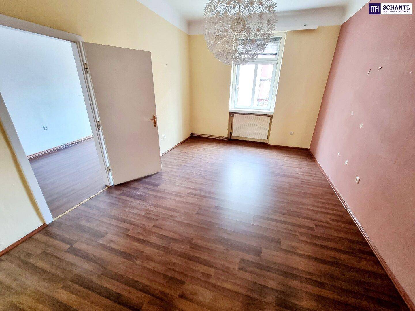 Geräumiger, leerer Raum mit Laminatboden und heller Wandfarbe, bereit zur individuellen Gestaltung.