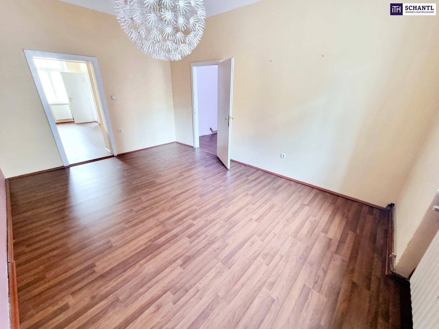 Geräumiger, leerer Raum mit Laminatboden und heller Wandfarbe, bereit zur individuellen Gestaltung.