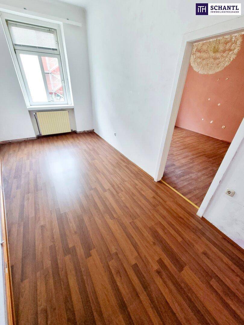 Heller, leerer Raum mit Laminatboden und Fenster, ideal für Schlaf- oder Wohnzimmer.