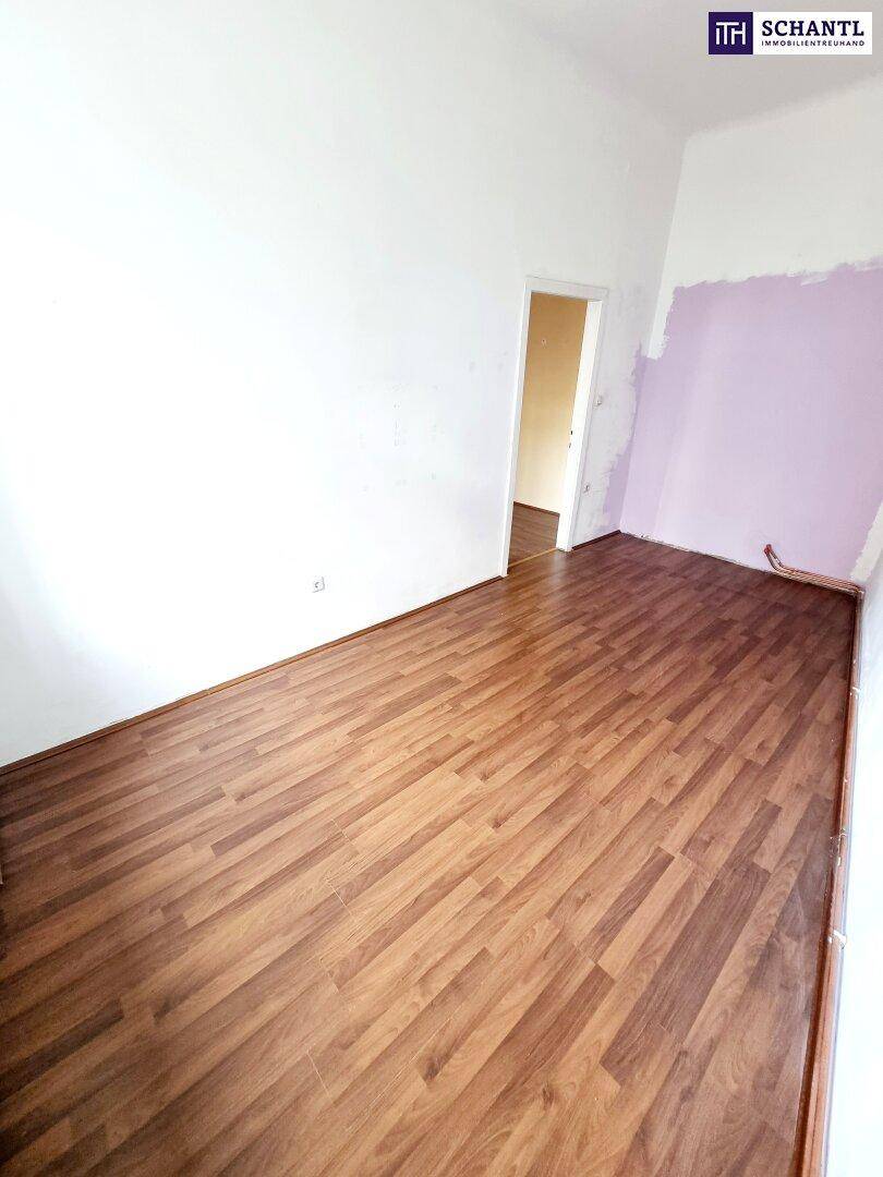 Geräumiger, leerer Raum mit Laminatboden und heller Wandfarbe, bereit zur individuellen Gestaltung.