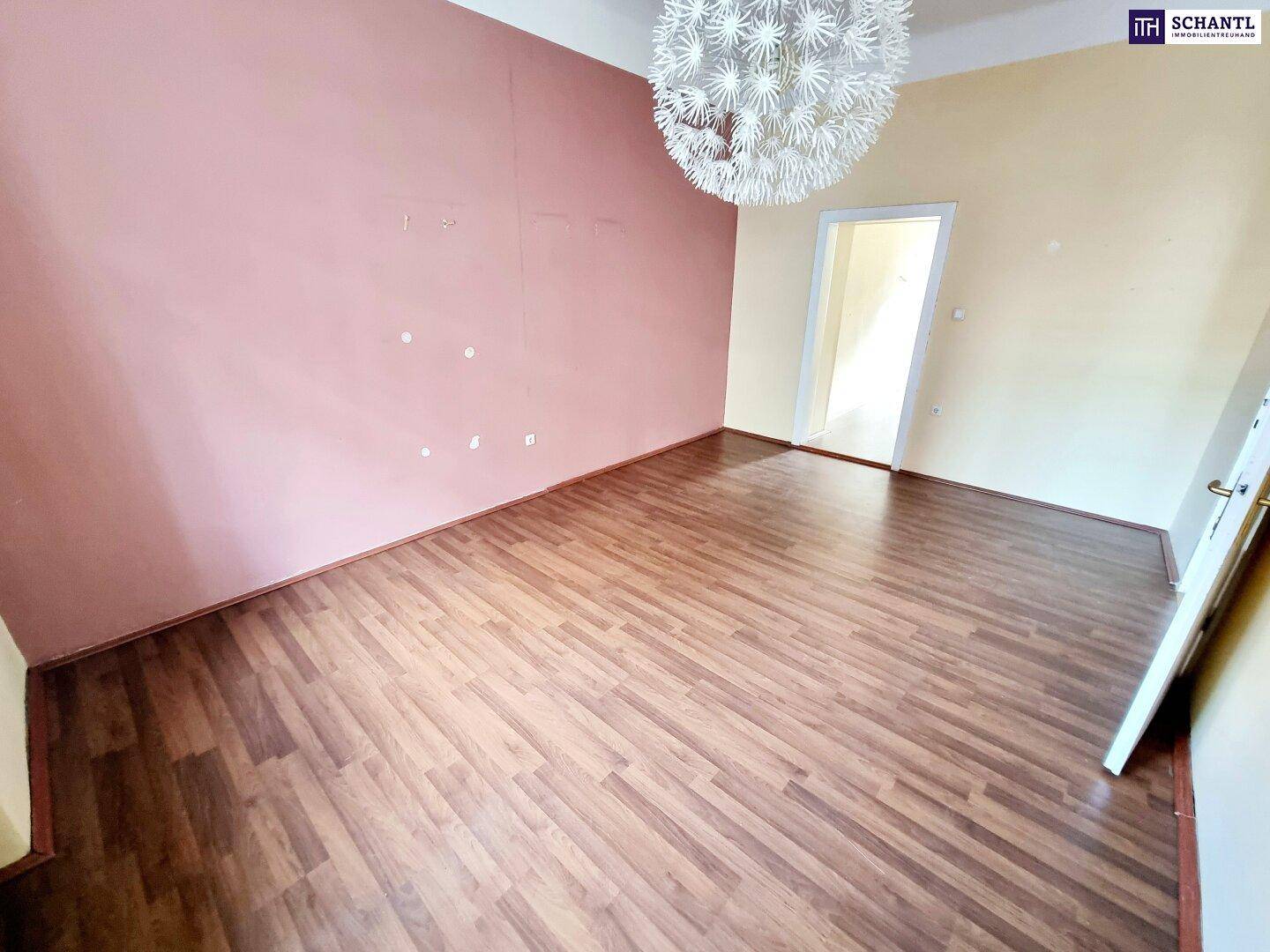 Geräumiger, leerer Raum mit Laminatboden und heller Wandfarbe, bereit zur individuellen Gestaltung.