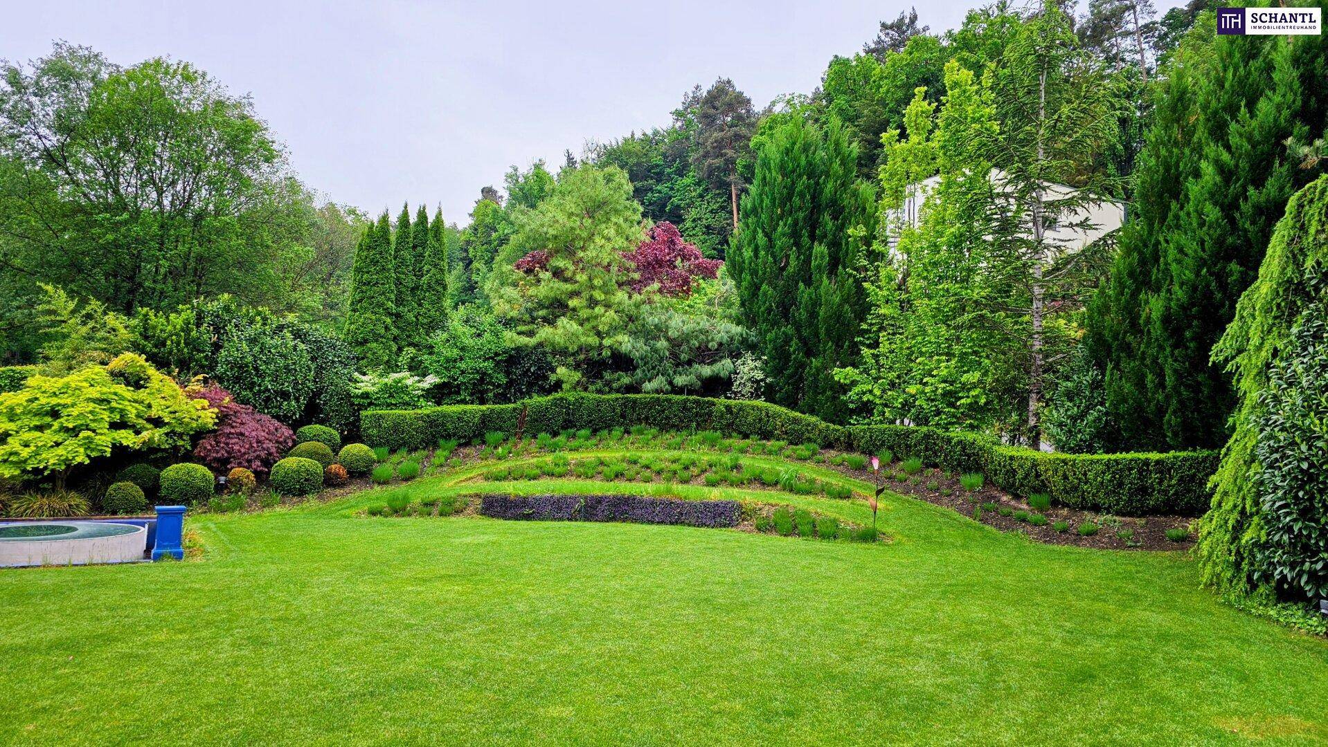 Weitläufiger, gepflegter Garten mit vielfältiger Bepflanzung und terrassierten Grünflächen.