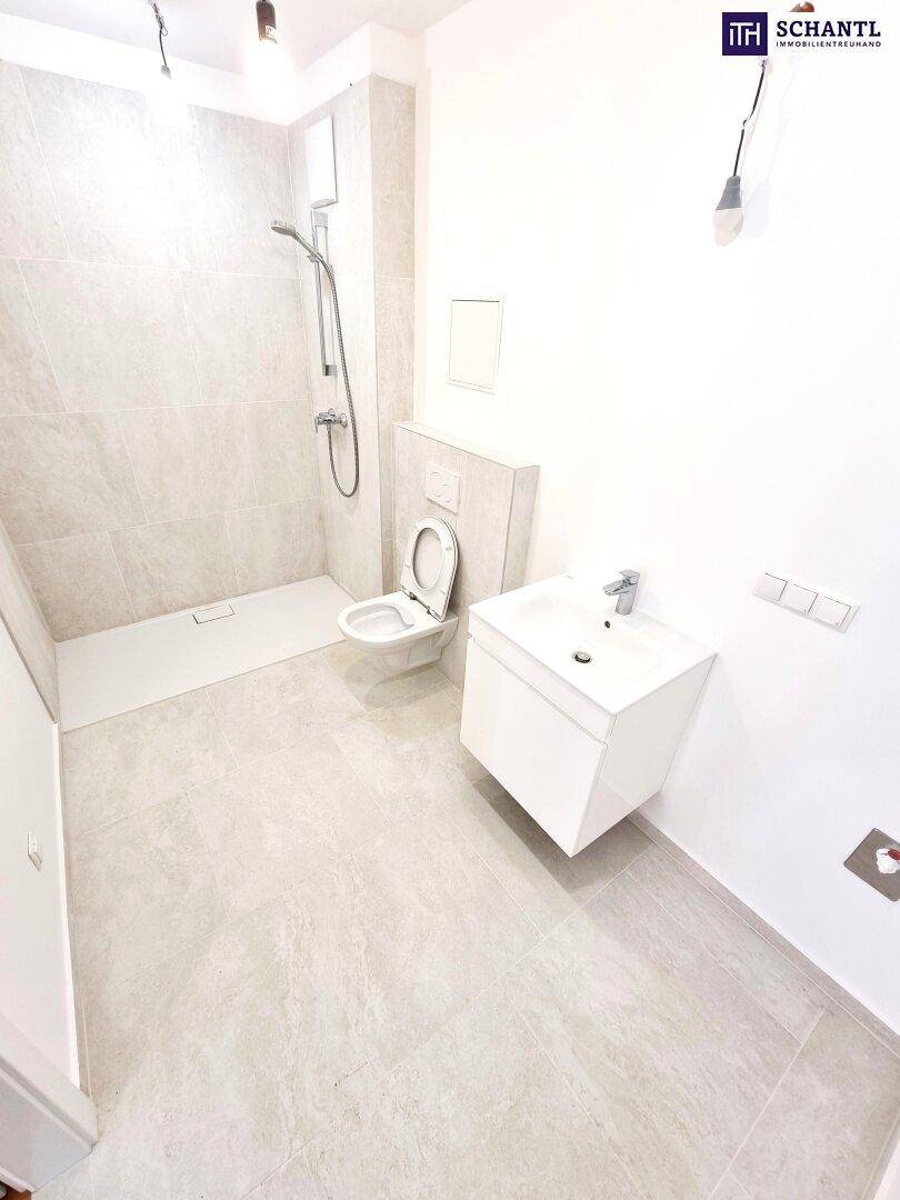 Modernes Badezimmer mit ebenerdiger Dusche, Hänge-WC und Waschbecken.