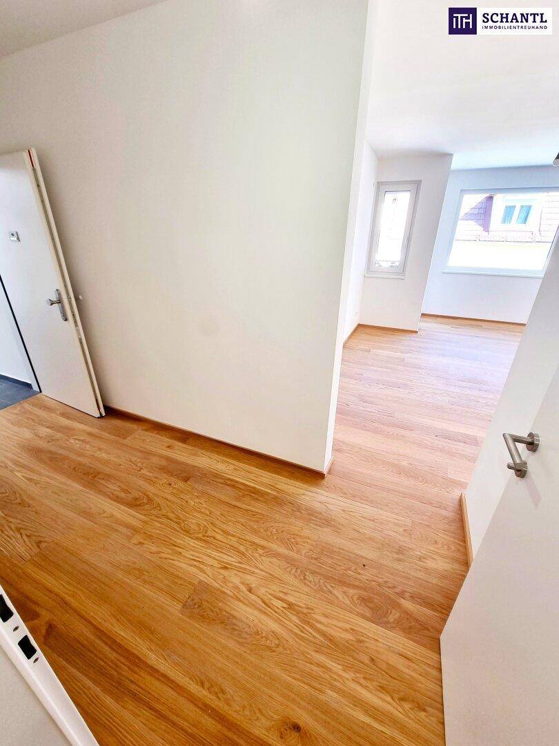 Heller Flur mit durchgehendem Holzboden, der zu weiteren Räumen führt.