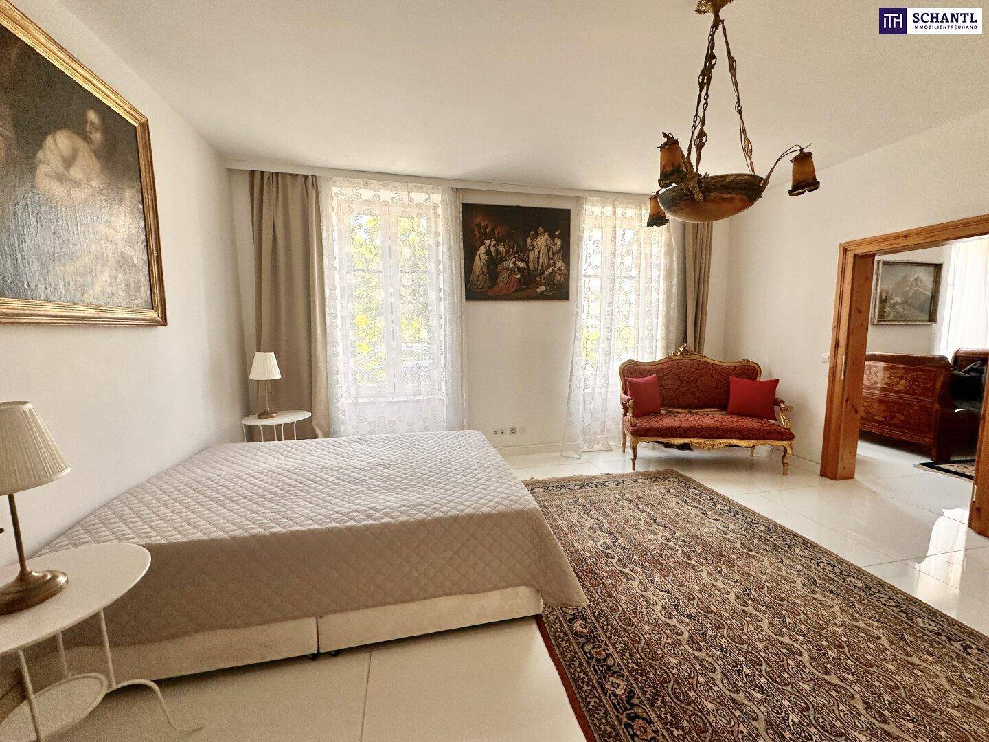 Elegantes Schlafzimmer mit Fliesenboden, großen Fenstern und klassischer Einrichtung.