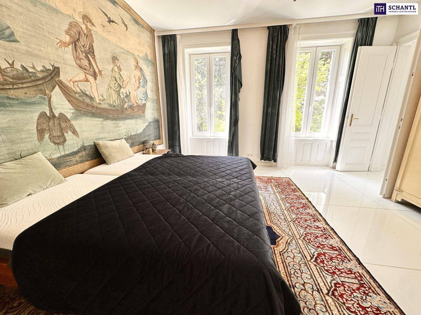 Geräumiges Schlafzimmer mit großem Wandteppich, Fliesenboden und hohen Fenstern.