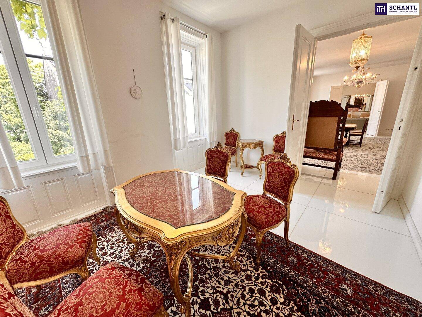 Elegantes Esszimmer mit antiken Möbeln, Fliesenboden und großen Fenstern.