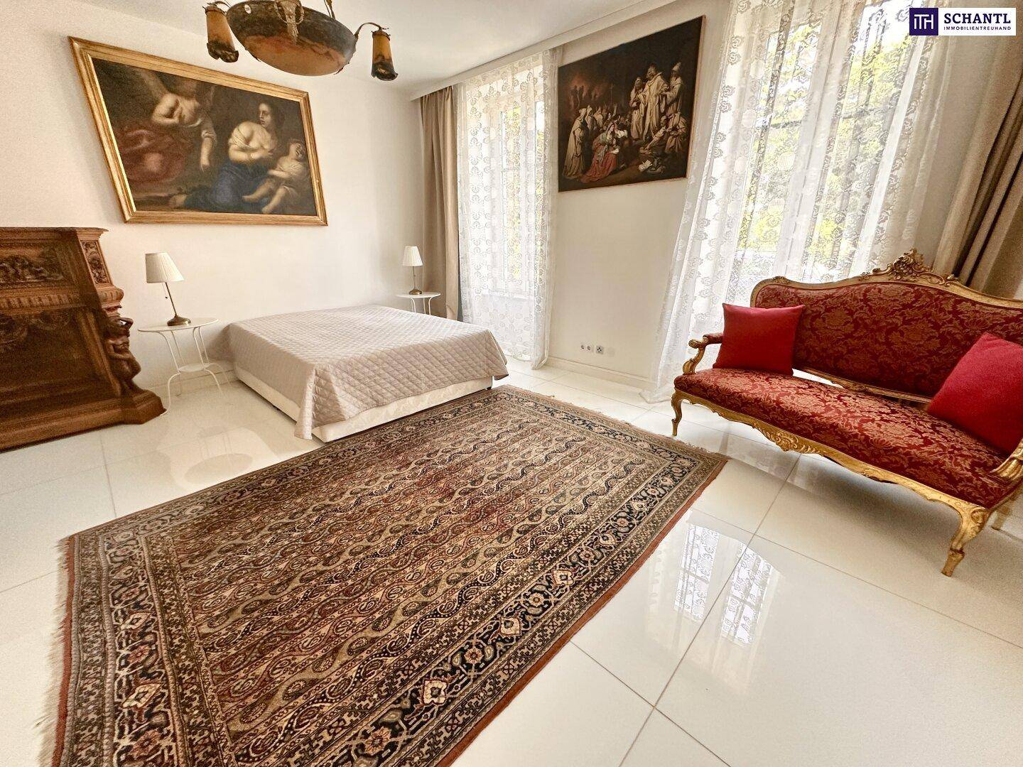 Großes Schlafzimmer mit Fliesenboden, antiken Möbeln und viel Tageslicht.