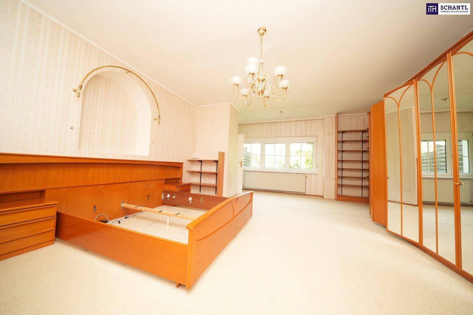 Geräumiges Schlafzimmer mit Teppichboden, Holzbettrahmen und Spiegelschränken, hell und klassisch eingerichtet.