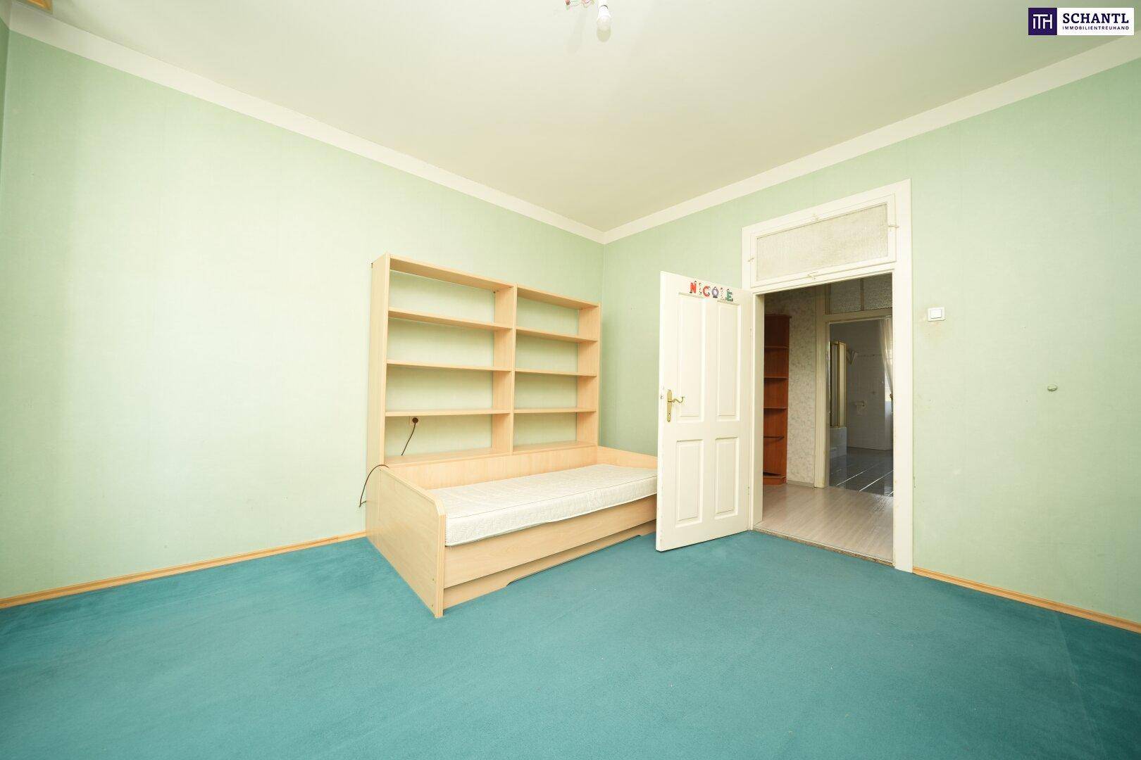 Kinderzimmer mit grün gestrichenen Wänden, Teppichboden und einem einfachen Bett mit Regal, gemütlich und hell.