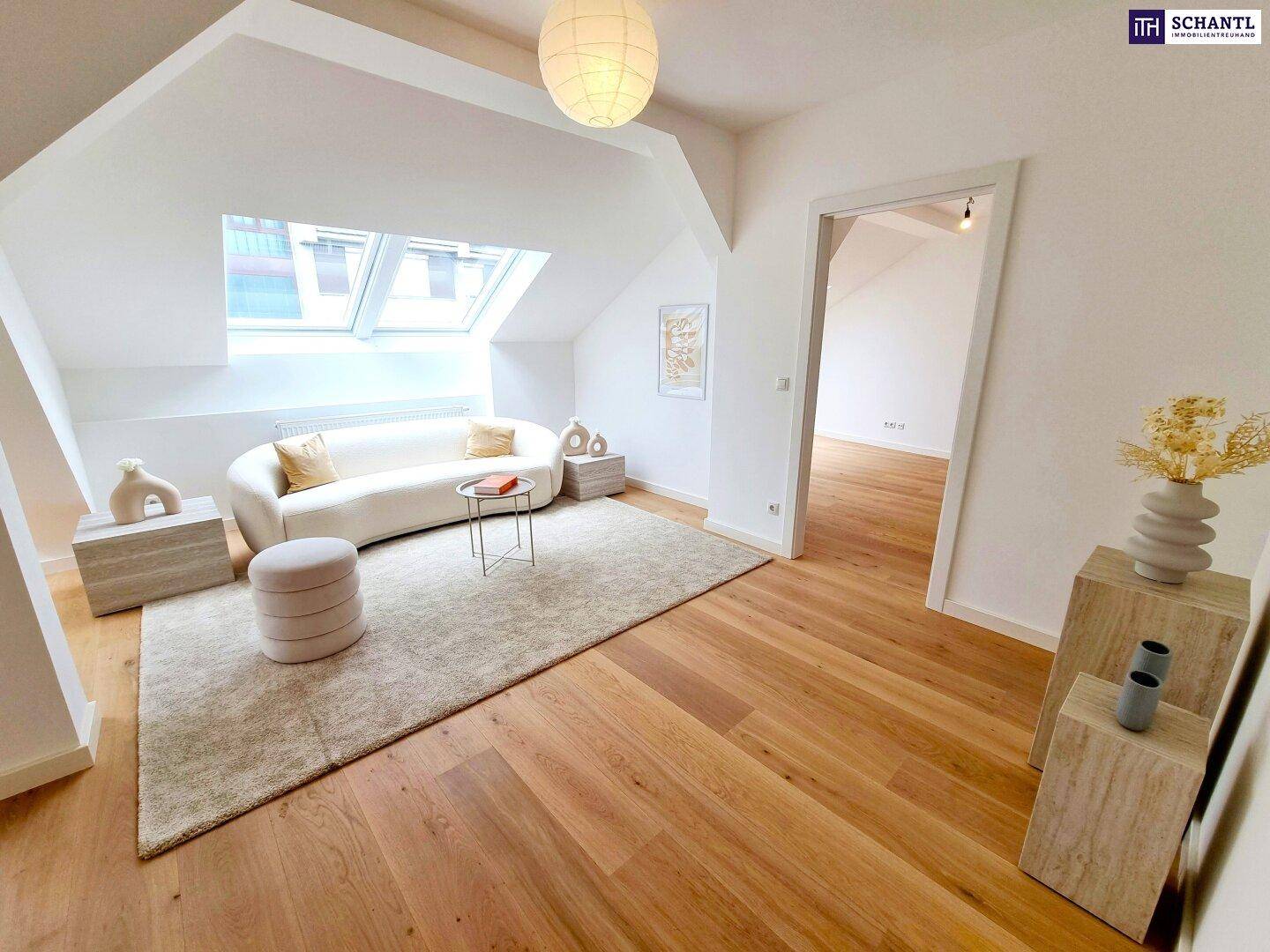 Gemütliches Wohnzimmer im Dachgeschoss mit bequemer Couch, Teppich und großen Dachfenstern.