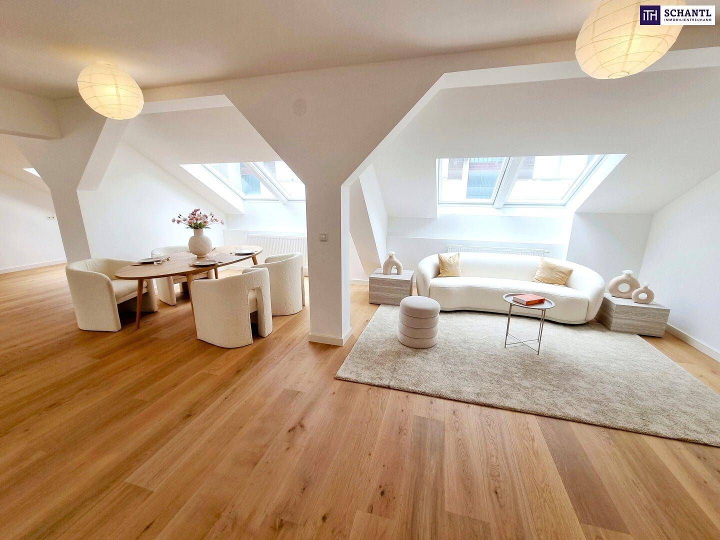 Offener Wohn- und Essbereich im Dachgeschoss mit Holzboden, modernen Möbeln und viel Tageslicht.