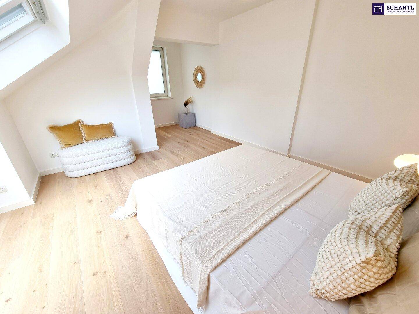 Geräumiges Schlafzimmer mit Holzboden, viel Tageslicht durch Dachfenster und moderner Dekoration.
