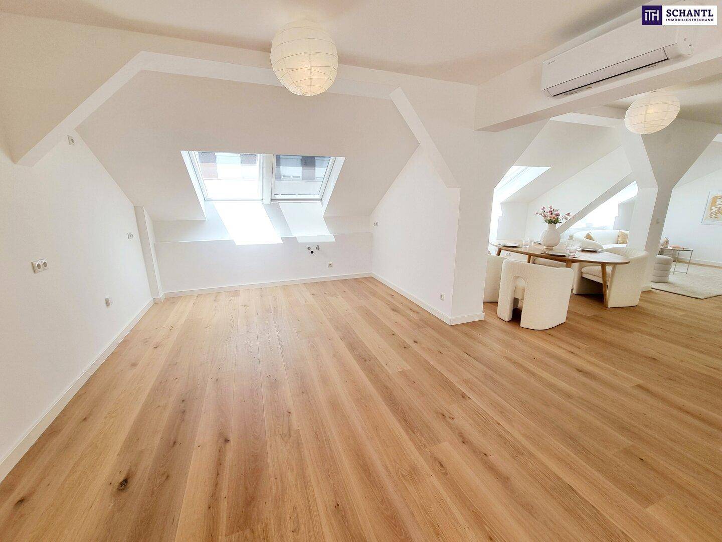 Geräumiger Wohn- und Essbereich im Dachgeschoss mit Holzboden und viel natürlichem Licht durch Dachfenster.