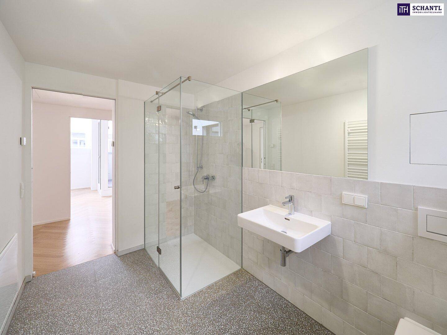 Modernes Badezimmer mit ebenerdiger Glasdusche, Einzelwaschbecken und großem Wandspiegel.