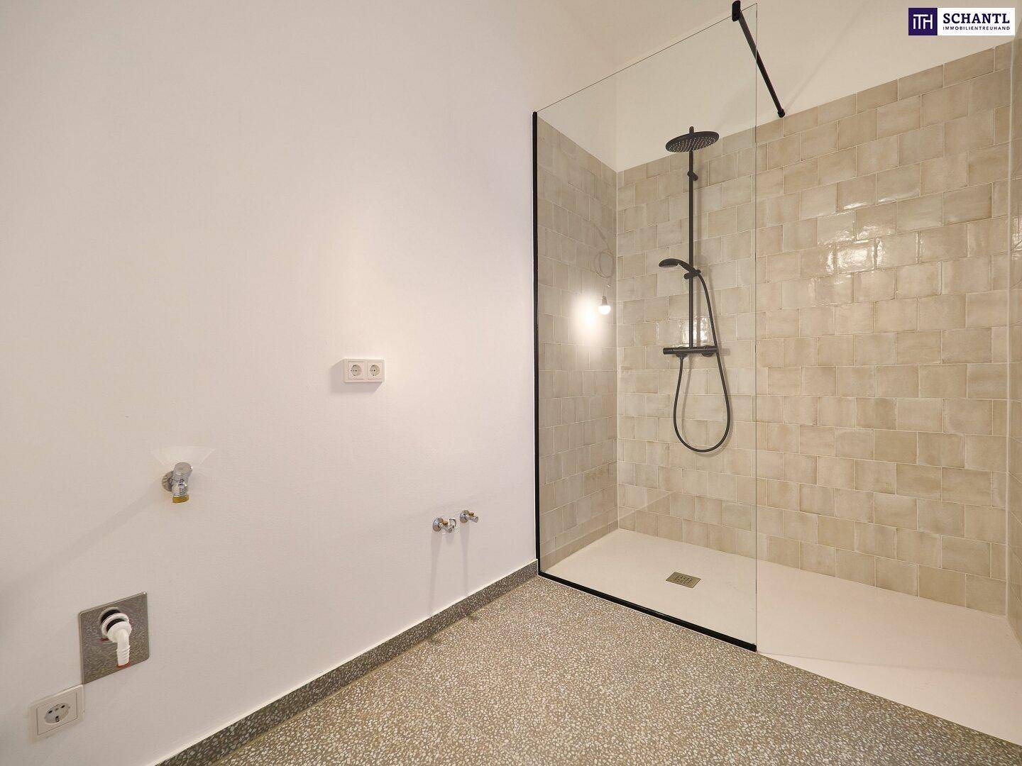 Modernes Badezimmer mit geräumiger ebenerdiger Dusche und vorbereiteten Anschlüssen für Waschtisch.