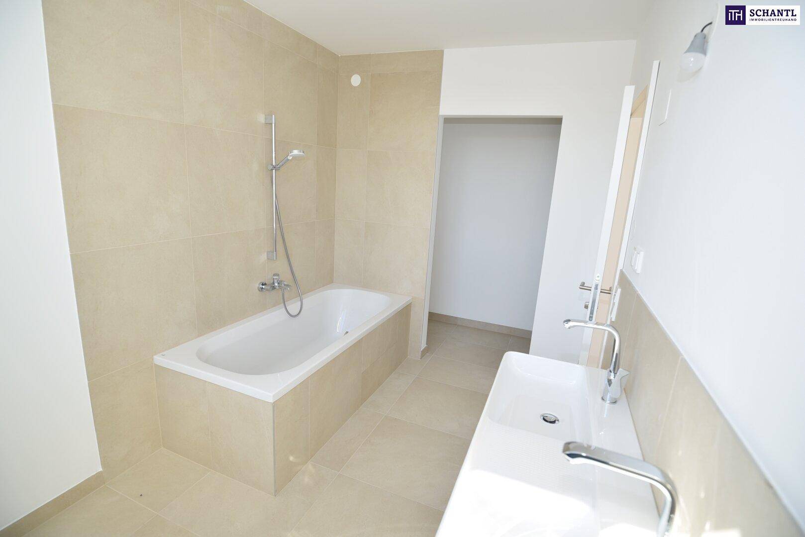 Modernes Badezimmer mit beigefarbenen Fliesen, einer Badewanne und einem einzelnen Waschbecken.