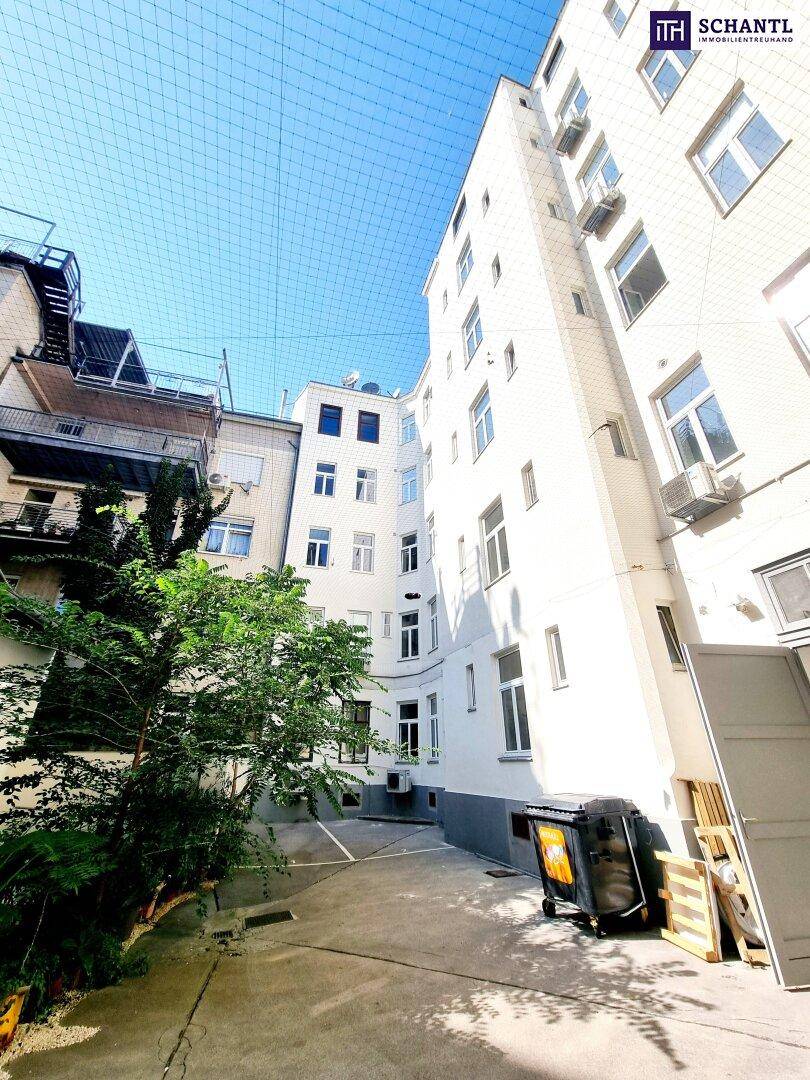 Innenhof eines Wohngebäudes mit Mülltonnen und Blick auf die Fassaden.