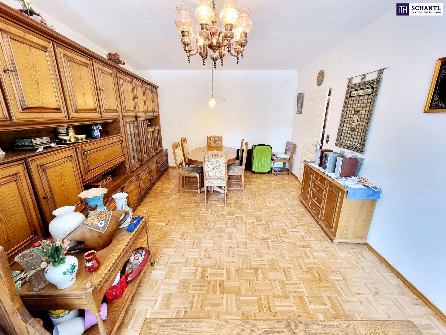 Essbereich mit traditionellen Holzmöbeln, Parkettboden und einem opulenten Kronleuchter.
